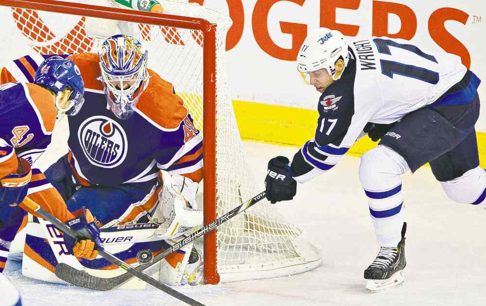Jason Franson / the canadian press
Winnipeg forward James Wright is denied by Edmonton goalie Devan Dubnyk and forward Will Acton during first-period action Tuesday night.