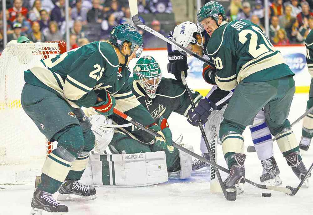 Jesse Johnson / usa today sports
The Wild's Jonas Brodin (25), Ryan Suter (20) and Josh Harding (37) spar for the puck with the Jets' Eric Tangradi in front of the Wild's net Thursday.