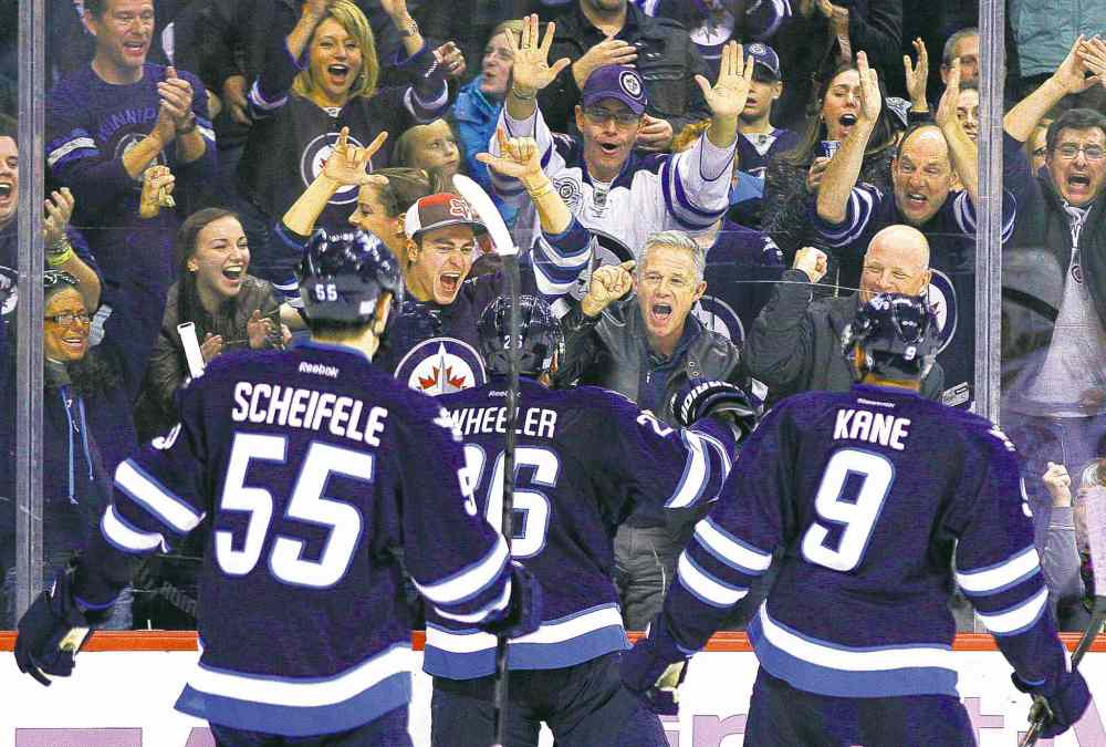 John Woods / WINNIPEG FREE PRESS
Winnipeg fans and Jets Mark Scheifele, Blake Wheeler and Evander Kane celebrate Wheelers' second-period goal Tuesday night.