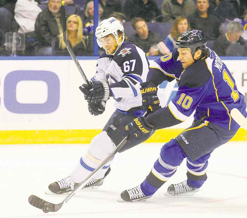 CP
Brenden Morrow of the Blues and the Jets' Michael Frolik battle for the puck Tuesday night.