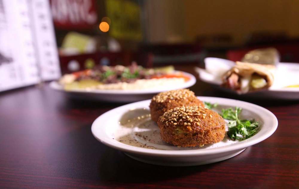 RUTH BONNEVILLE / WINNIPEG FREE PRESS
Middle Eastern fare at Ramallah includes falafel (centre), hummus platter with beef (left) and chicken shawarma wraps.