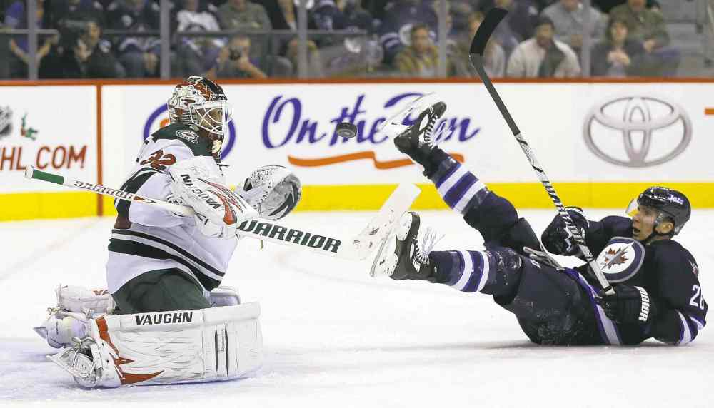 TREVOR HAGAN / WINNIPEG FREE PRESS
Minnesota Wild goalie Niklas Backstrom keeps his eye on the airborne puck as Jets� Blake Wheeler takes a spill in front of him in the second period Saturday.