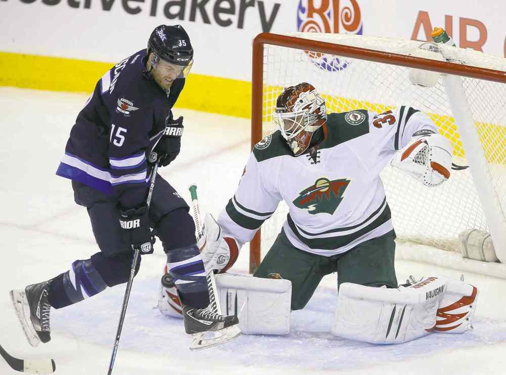 TREVOR HAGAN / WINNIPEG FREE PRESS
Jets� Matt Halischuk jumps over a shot as he tries to screen Wild goaltender Niklas Backstrom in the first period Saturday afternoon.