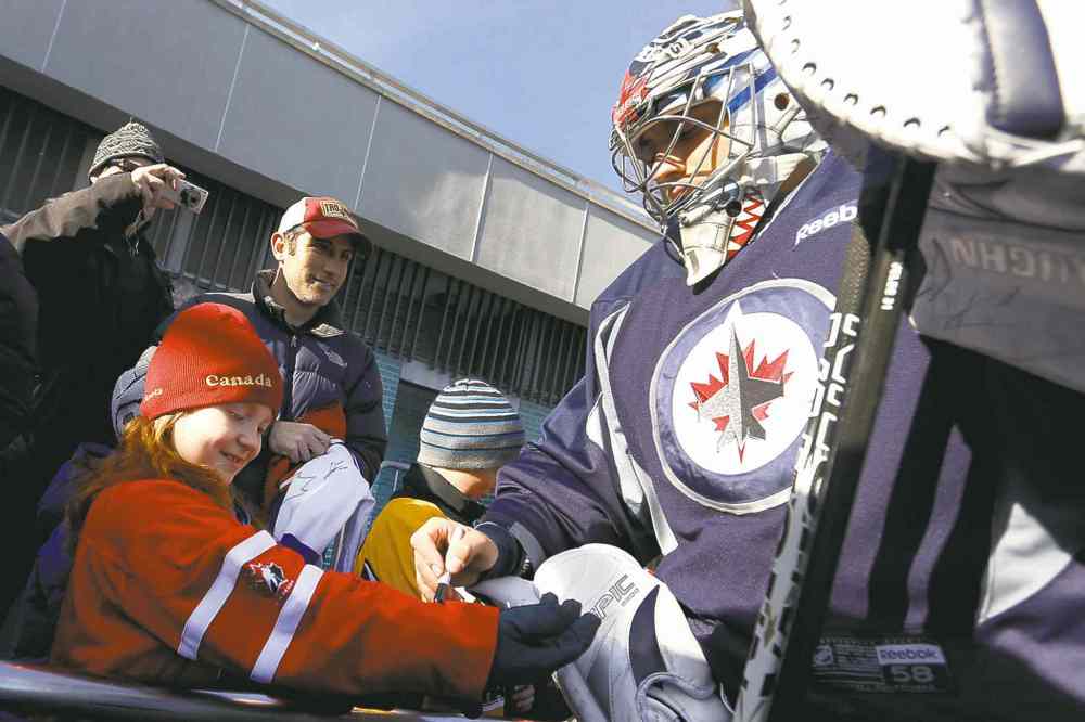 CP
Goalie Ondrej Pavelec signs an autograph for fan Alison Giebler, 8, of New York, before the team held their outdoor practice.