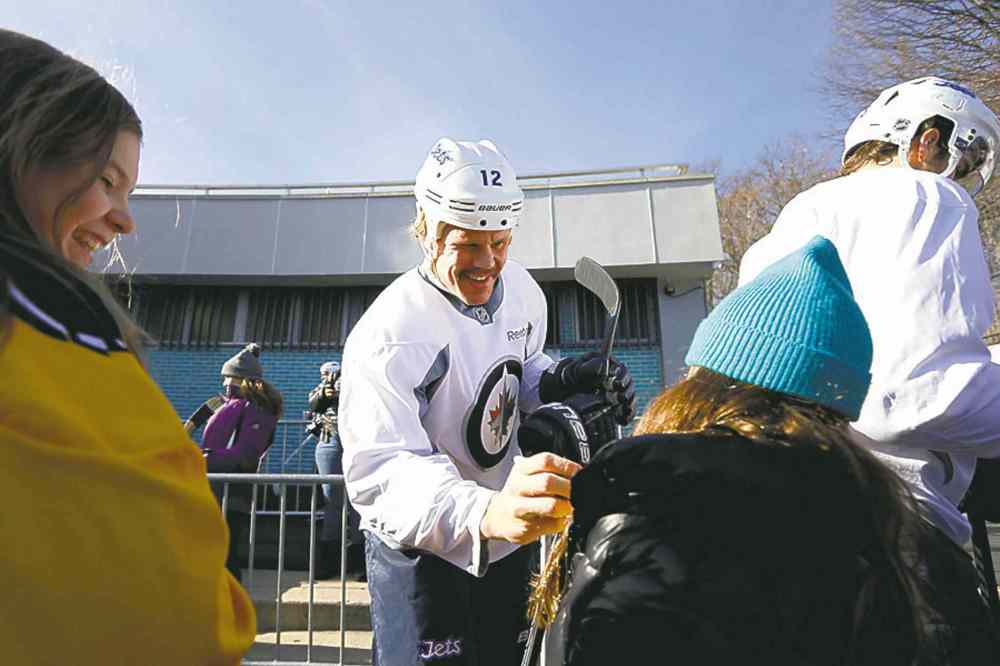 CP
Olli Jokinen signs for a couple of young fans who showed up for the team�s practice.