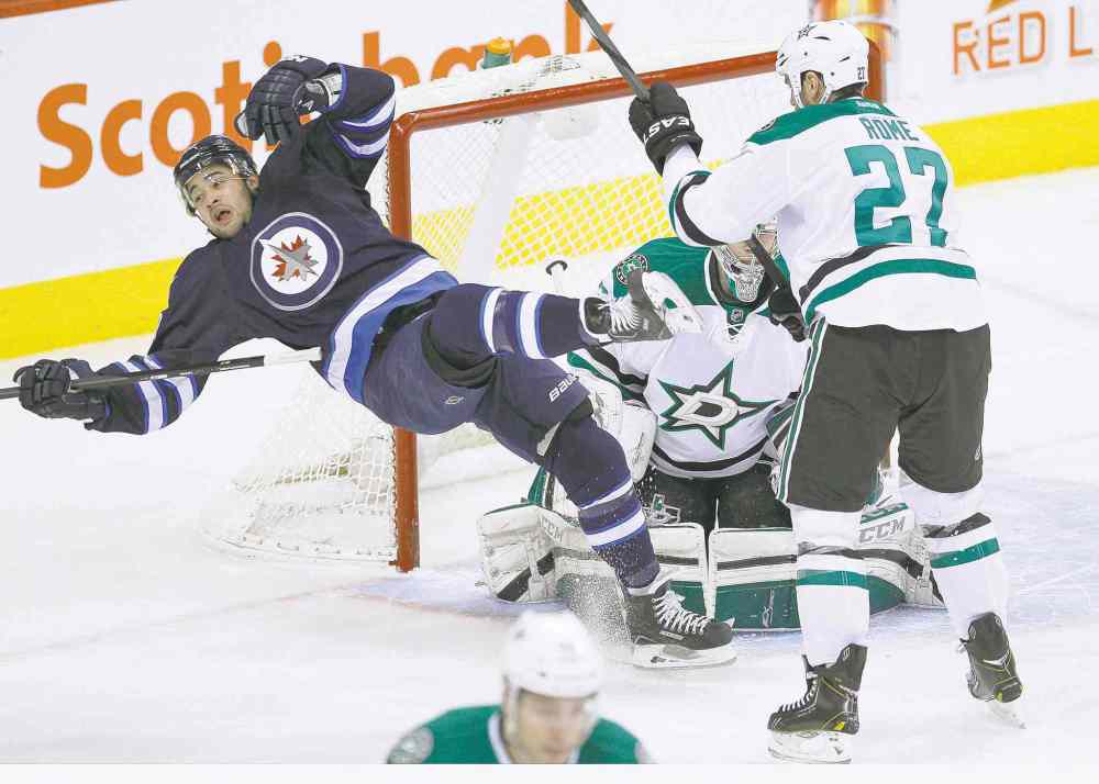 CP
John Woods / the canadian press
Dallas Stars� Aaron Rome sends Jet Devin Setoguchi flying as goaltender Kari Lehtonen looks for the puck during first-period play.