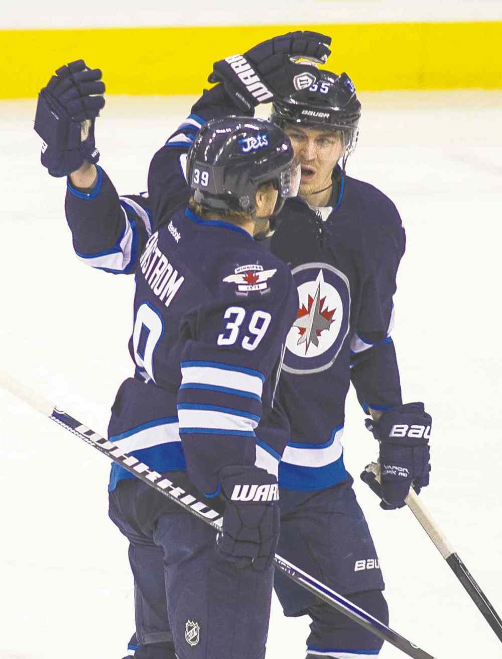 The Jets' Tobias Enstrom (39) celebrates his goal with a Mark Scheifele during the first period Friday.