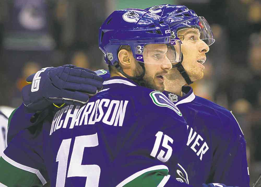 CP
Brad Richardson (left) and David Booth celebrate Richardson's tip-in power-play goal against the Jets during the first period in Vancouver.
