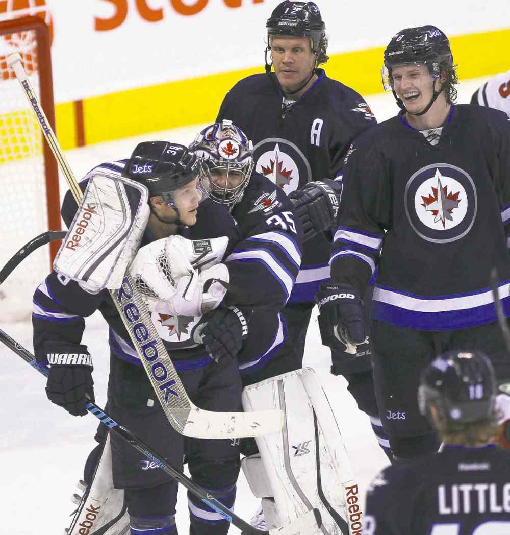 JOE BRYKSA / WINNIPEG FREE PRESS
Jets goalie Al Montoya hugs teammate Tobias Enstrom as Olli Jokinen (rear left) and Jacob Trouba (right) look on.