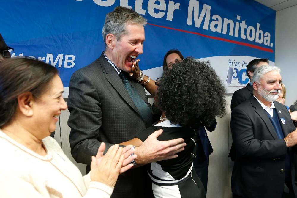 JOHN WOODS / WINNIPEG FREE PRESS files
Kenny Daodu wipes her lipstick from Brian Pallister’s lips after she kissed the PC leader during a party rally earlier this month.