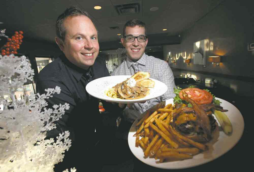 Phil Hossack / Winnipeg Free Press
Oakwood Caf�� partners Peter Paley (left) and Alix Loiselle hold their favourite dishes, beef stroganoff and the Oakwood burger, respectively. A breakfast/lunch/dinner nook in trendy south Osborne, the Oakwood was one of the first restaurants in the area.