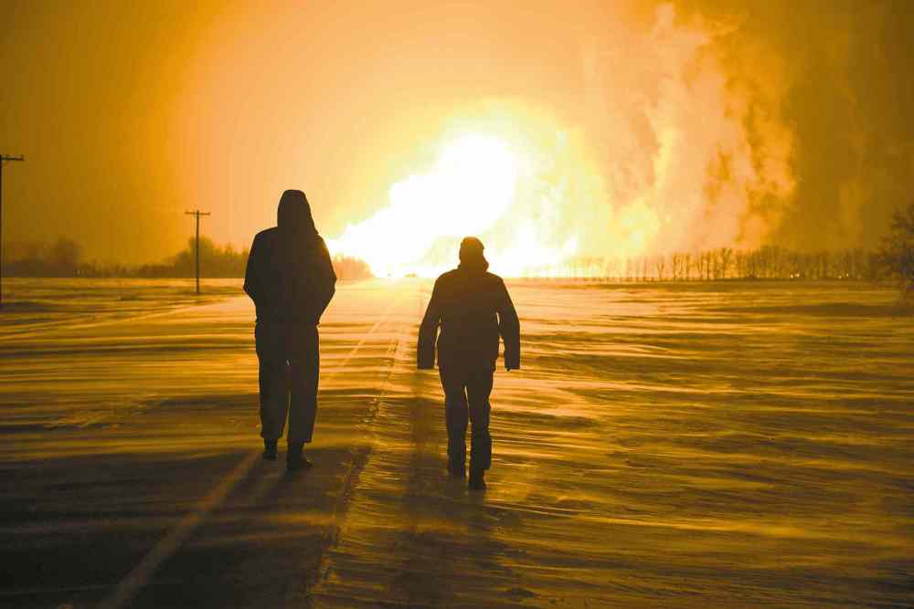 Jordan McRae photo
Onlookers watch as fire from a natural-gas pipeline explosion near Otterburne, 60 kilometres south of Winnipeg, lights up the sky on Saturday morning.
