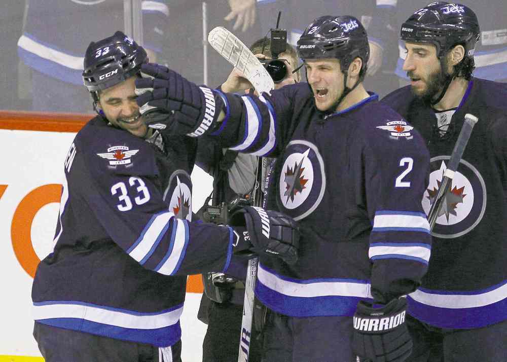 CP
John Woods / THE CANADIAN PRESS
Dustin Byfuglien (33) gets a happy pat from Adam Pardy (2) after scoring the winner in overtime against the Leafs last night.