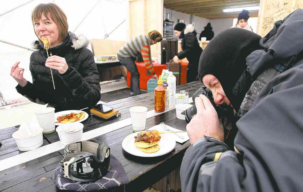 MIKE DEAL / WINNIPEG FREE PRESS
Brent Lelond takes a photo of his brunch at the Raw: Almond pop-up restaurant on the river ice at The Forks on Sunday as another customer enjoys her food.