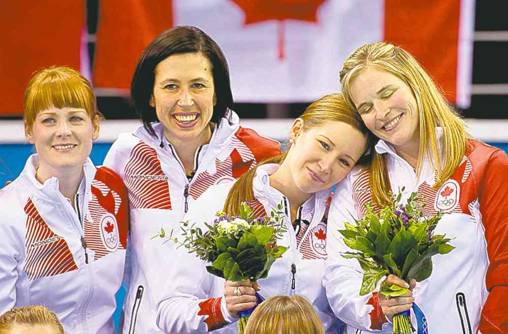 Adrian Wyld / the canadian press
Canada skip Jennifer Jones (right) and third Kaitlyn Lawes rest their heads on each other on the podium with lead Dawn McEwen (left) and second Jill Officer.