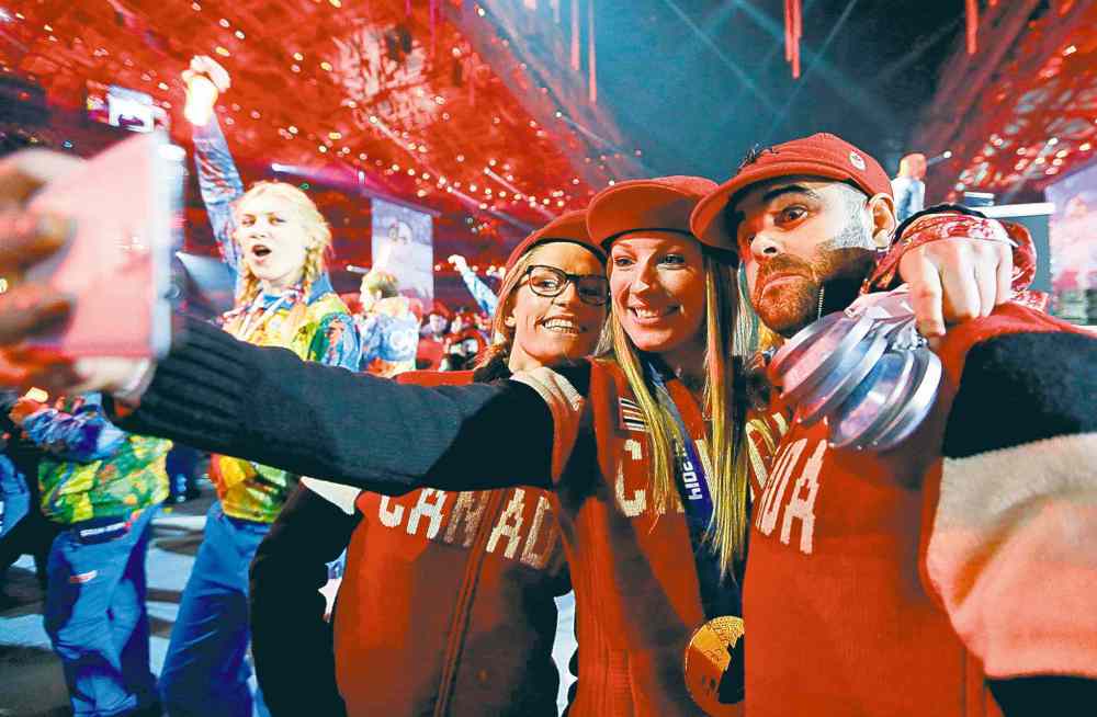 darron cummings / the associated press
Canadian athletes take a self-portrait with a mobile phone during the closing ceremony.