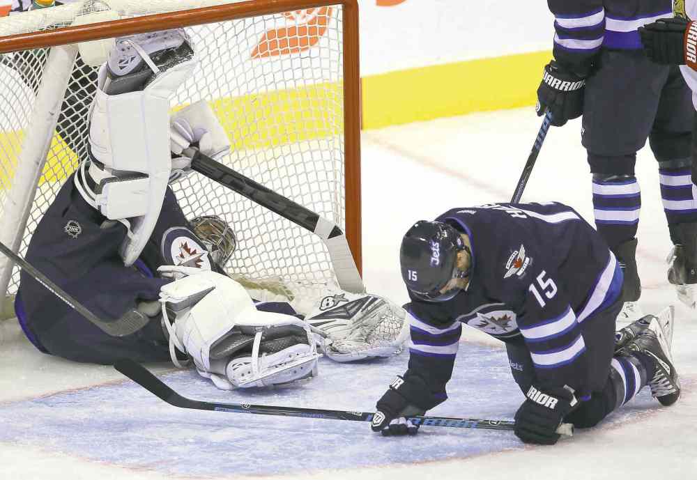Trevor Hagan / Winnipeg Free Press
Jets goaltender Ondrej Pavelec sprawls in the net after the puck took a strange bounce off Matt Halischuk (15) and crossed the line. Ottawa's Milan Michalek got credit for the goal.