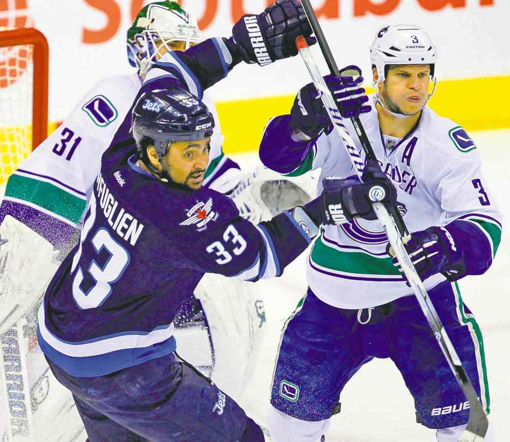 Boris Minkevich / Winnipeg Free Press
Winnipeg's Dustin Byfuglien dukes it out with Vancouver's Kevin Bieksa in front of the Canucks net in the second period.