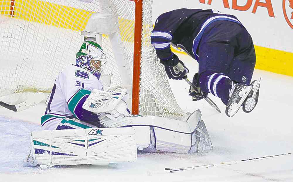 BORIS MINKEVICH / WINNIPEG FREE PRESS
Jets' defenceman Jacob Trouba takes a tumble in front of Eddie Lack.
