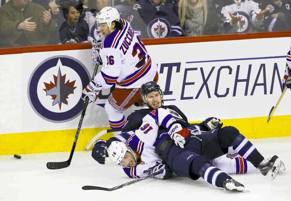 TREVOR HAGAN / WINNIPEG FREE PRESS
Jets� Bryan Little lands on Rangers� Derick Brassard as New York�s Mats Zuccarello skates past with the puck Friday night.
