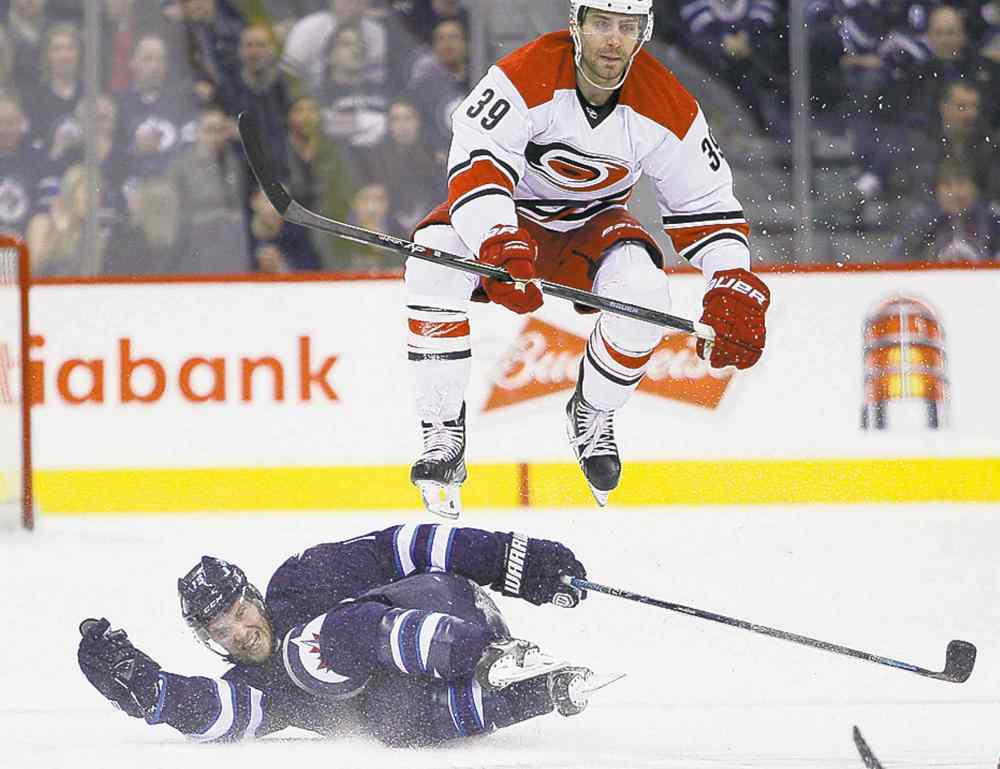 John Woods / The Canadian Press
Carolina's Patrick Dwyer leaps over Winnipeg's Matt Halischuk.