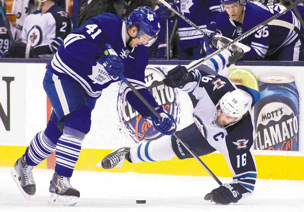 Nathan Denette / the canadian press
Leafs forward Nikolai Kulemin employs a bit of stickwork to send Jets captain Andrew Ladd flying during second-period action in Toronto.