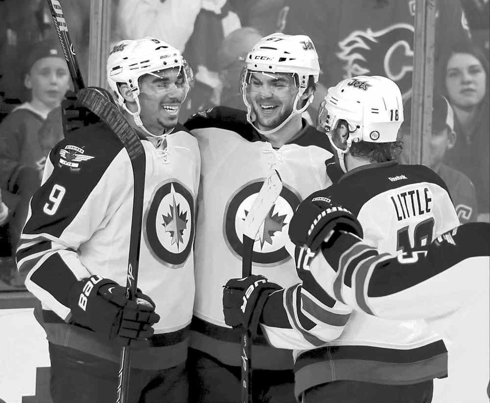 CP
Larry MacDougal / the canadian press
There are grins all around as Jet Michael Frolik (centre) celebrates his goal against the Flames with Evander Kane (left) and Bryan Little.