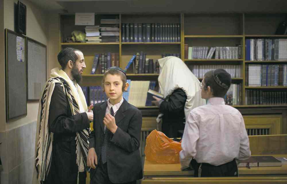 Alexander Zemlianichenko / The Associated Press
Jewish men and boys prepare to read prayers in a synagogue in Donetsk, Ukraine, on Friday. A pro-Russian separatist group denies it is the source of anti-Semitic flyers in that city.
