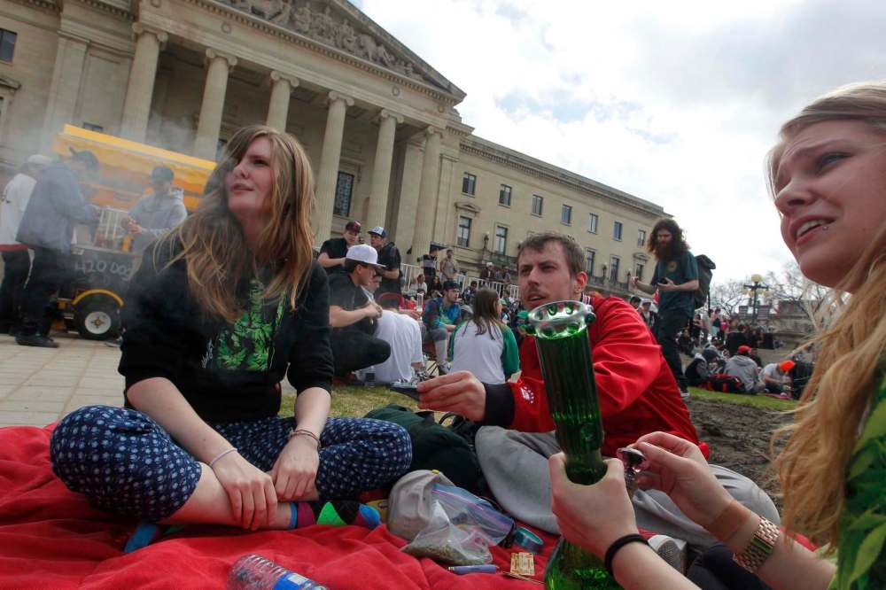 photos by BORIS MINKEVICH / WINNIPEG FREE PRESS
Eric Sorrie, with fellow marijuana advocates (top), lights up at the legislature Tuesday during 4/20 celebrations.