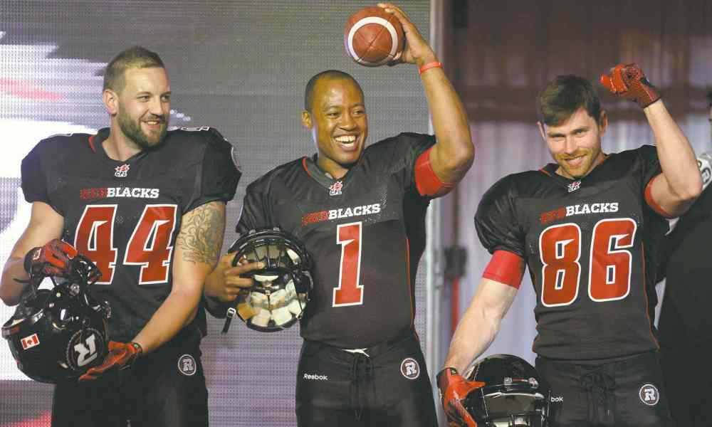 THE CANADIAN PRESS/Sean Kilpatrick
Redblacks veteran CFL quarter back Henry Burris sports the team's home uniform alongside teammates in Ottawa on Tuesday, May 6, 2014.