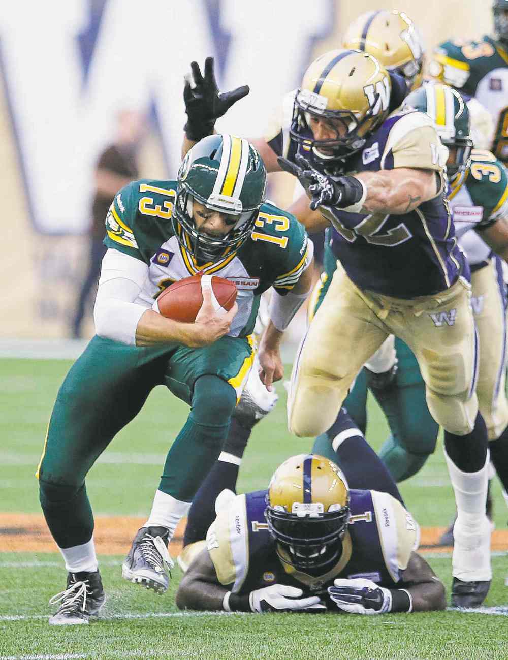 CP
John Woods / the canadian press files
Wily Eskimos quarterback Mike Reilly eludes Bombers would-be tacklers for the nth time Thursday night.