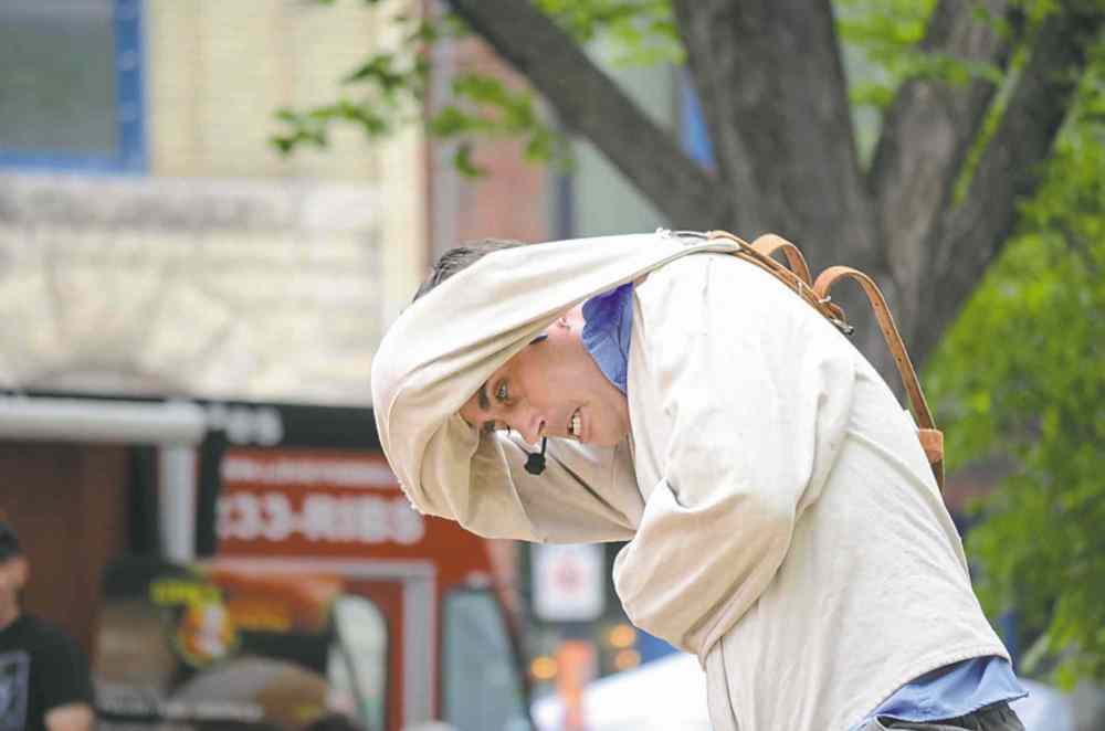 Oliver Sachgau / Winnipeg Free Press
Chris Visser (below) escapes out of a straightjacket at Old Market Square. Though he only makes money from what people donate, Visser says not paying for a venue makes up for that.