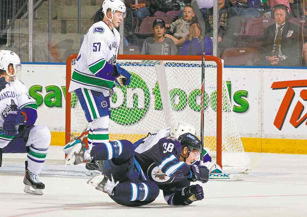 JEFF VINNICK IMAGES
Centre Nic Petan hits the ice after hitting paydirt, scoring the overtime winner against the Canucks Sunday in Penticton, B.C.