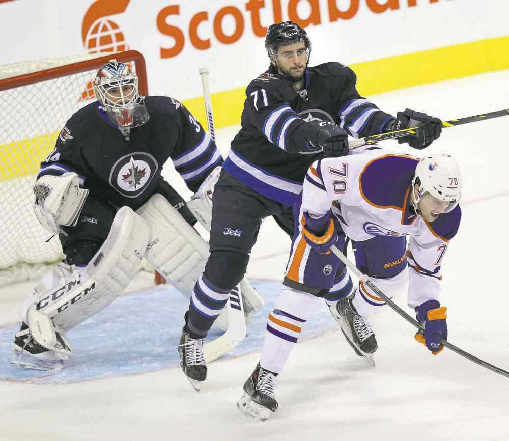 Phil Hossack / Winnipeg Free Press
Winnipeg blue-liner Julian Melchiori hammers Edmonton forward Curtis Hamilton during pre-season action at the MTS Centre Wednesday.