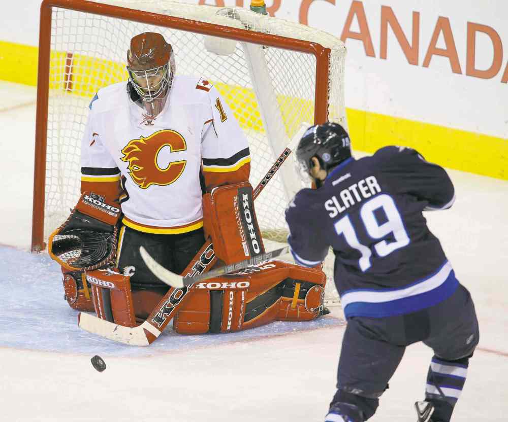 TREVOR HAGAN / WINNIPEG FREE PRESS
Flames goaltender Jonas Hiller stymies Winnipeg�s Jim Slater during the third period Saturday night at the MTS Centre.