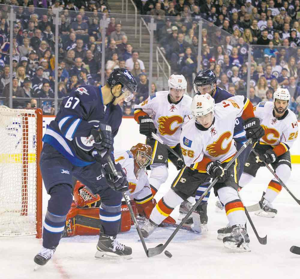 CP
David Lipnowski / the canadian press
Calgary goaltender Jonas Hiller scrambles to stop Michael Frolik.