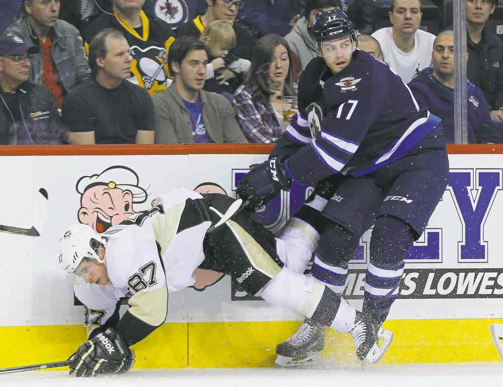 CP
Winnipeg centre Adam Lowry hammers Pittsburgh superstar Sidney Crosby during the second period of Thursday�s hard-hitting affair at the MTS Centre.