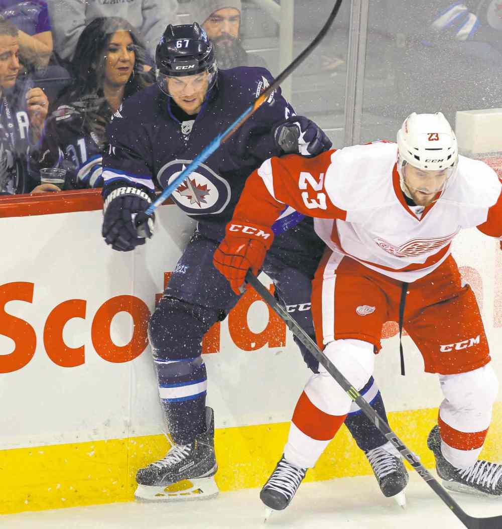 BORIS MINKEVICH / WINNIPEG FREE PRESS
Winnipeg�s Michael Frolik battles Detroit�s Brian Lashoff for the puck during Thursday�s action.