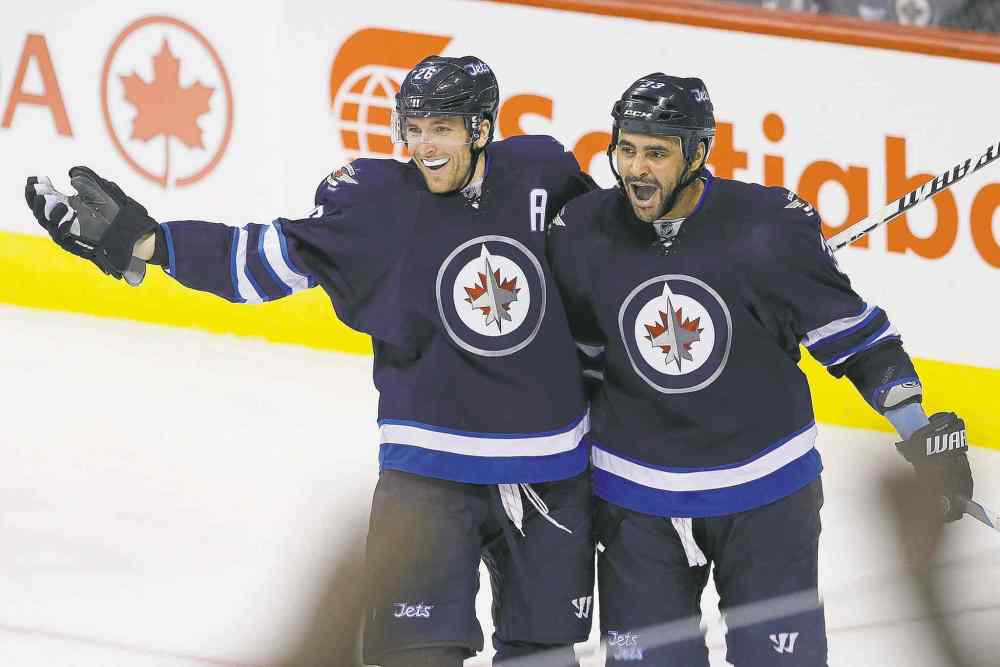 John Woods / Winnipeg Free Press
Winnipeg Jets forward cum blue-liner Dustin Byfuglien (right) and Blake Wheeler celebrate Byfuglien's first-period power-play goal Sunday against the Anaheim Ducks.