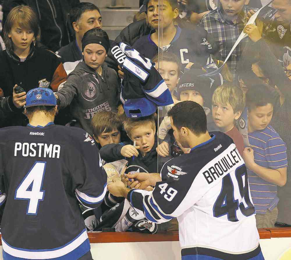 Phil Hossack / Winnipeg Free Press
A young fans proffers a pen hoping for an autograph after enduring a crush for autographs.