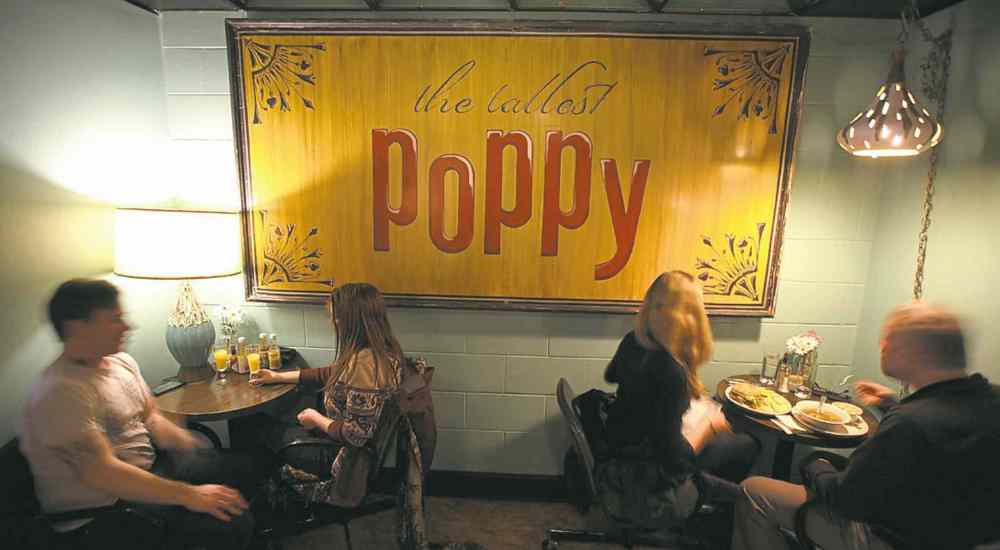 A sign that was formerly on the outside of the Tallest Poppy�s Main Street location now hangs inside its new location.