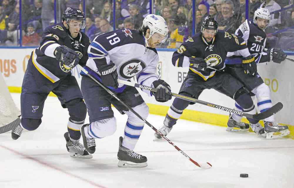 CP
tom gannam / the associated press
The Blues� Petteri Lindbohm (left) tries to poke the puck away from the Jets� Jim Slater Tuesday. A valiant comeback fell short when the Blues broke the 4-4 tie on a softy on Ondrej Pavelec from centre ice.
