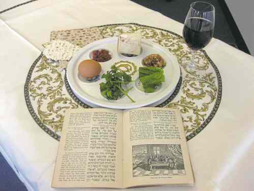 CP
This Tuesday, March 15, 2011 photo shows a 1936 Maxwell House Haggadah alongside a Seder plate in New York. The coffee maker's version of the Seder guide has been offered free at supermarkets with a Maxwell House purchase since the early 1930s. A major overhaul will be out this year in time for the holiday's start April 19.   (AP Photo/Stace Maude)