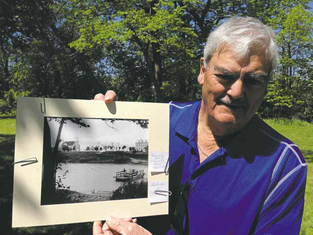 Bob LaFleche, 76, holds a photo of the St. Charles ferry crossing the Assiniboine River. His family's 1953 Ford is on board.