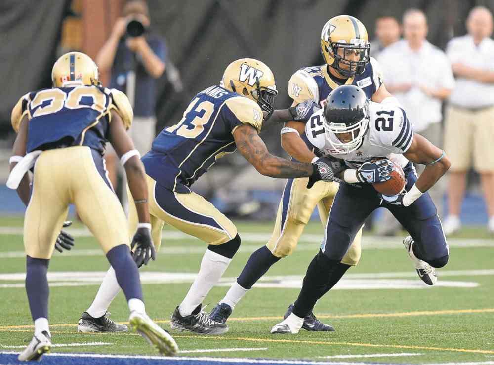 Frank Gunn / THE CANADIAN PRESS
Bomber defenders Don Unamba (13) and Teague Sherman (27) close in on the Toronto Argonauts' Vidal Hazelton.