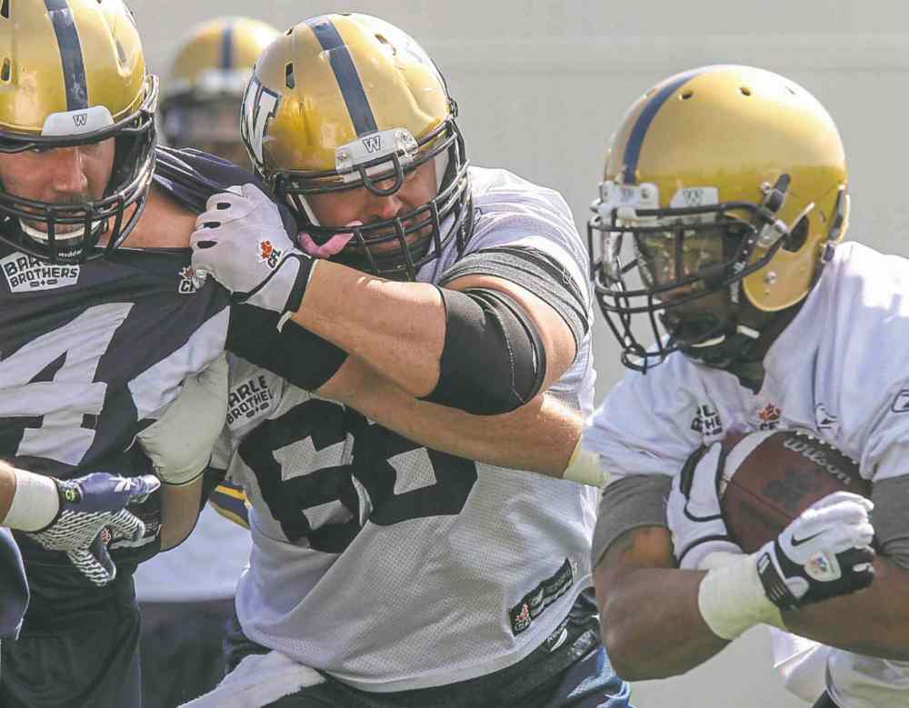 MIKE DEAL / WINNIPEG FREE PRESS FILES
Dominic Picard (centre) isn't just a force on the O-line, he is also critical in pre-game prep for the hogs.