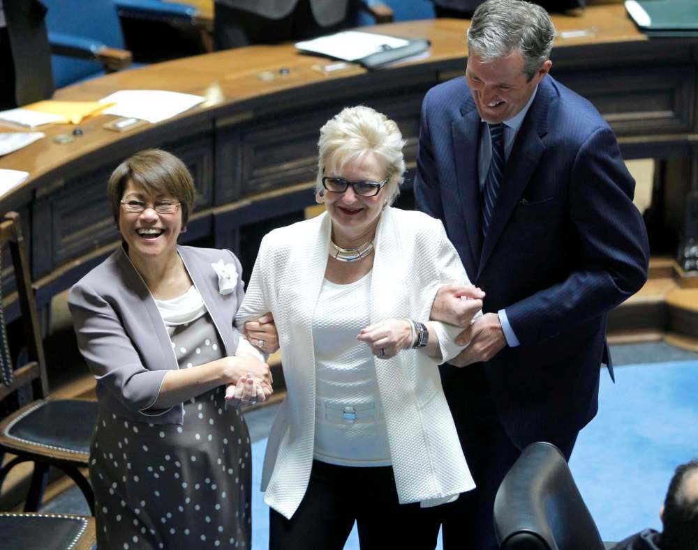 BORIS MINKEVICH / WINNIPEG FREE PRESS
NDP interim leader Flor Marcelino (left) and MB Premier Brian Pallister (right) march Tory Myrna Driedger, elected Speaker of Manitoba legislature.