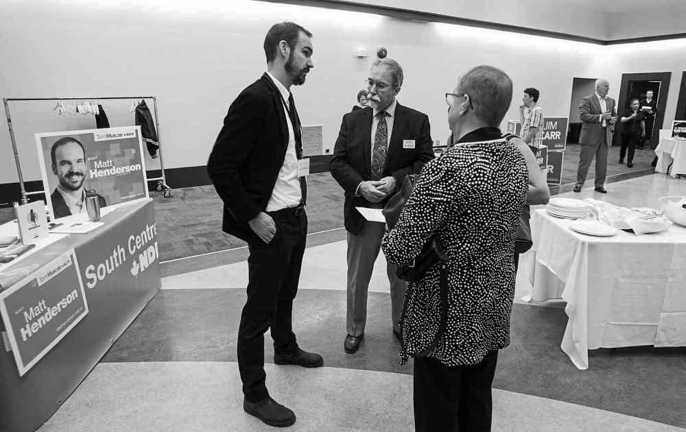 MIKE DEAL / WINNIPEG FREE PRESS
Winnipeg South Centre NDP candidate Matt Henderson (left), talks to members of the chamber Wednesday.