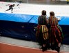 Women in traditional dresses watch Nico Ihle of Germany and Laurent Dubreuil,left, of Canada during a men's 500-meter division A heat at the speedskating World Cup at the Arena-Lodowa Speed Skating Stadium, in Tomaszow Mazowiecki, Poland, Saturday, Dec. 8, 2018. (AP Photo/Czarek Sokolowski)