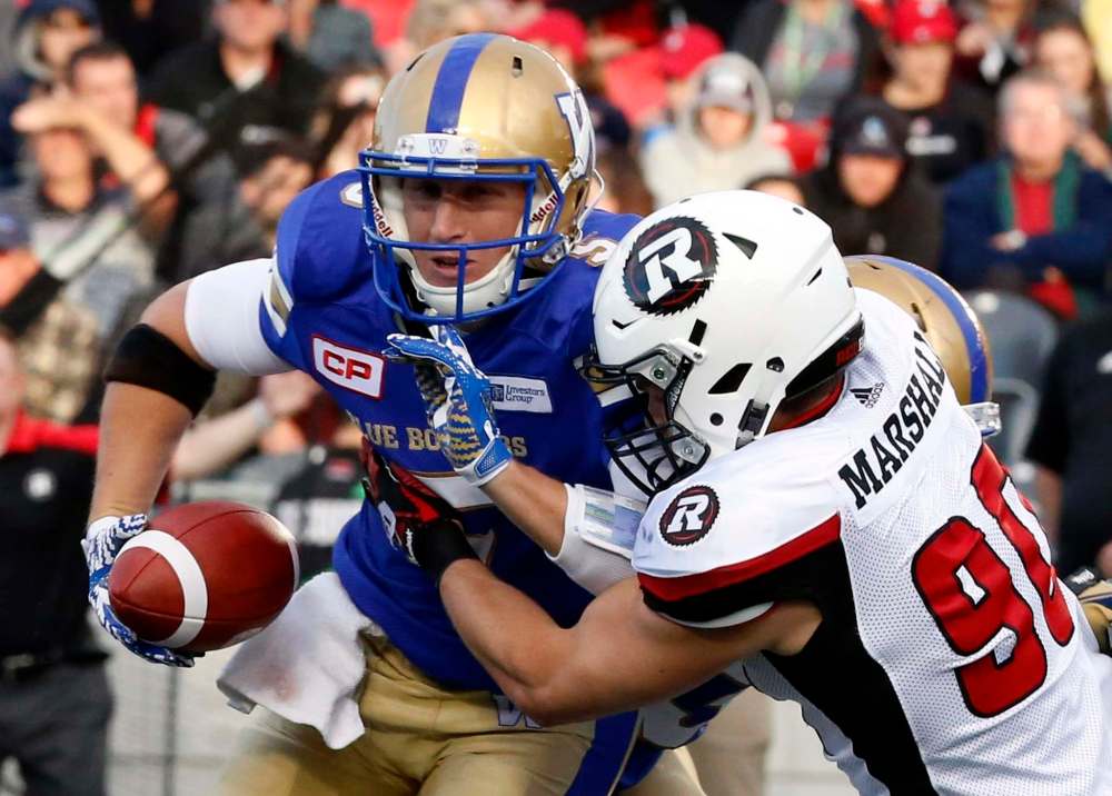 FRED CHARTRAND / THE CANADIAN PRESS
Ottawa Redblacks' Andrew Marshall (90) stops Winnipeg Blue Bombers quarterback Drew Willy (5) during pre-season CFL football action in Ottawa Monday.